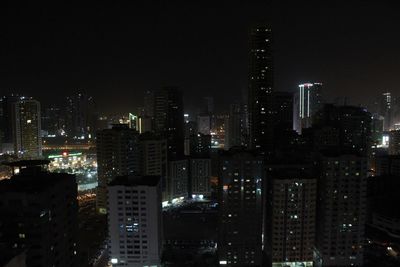 Illuminated buildings in city against sky at night