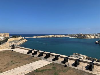 High angle view of buildings by sea against blue sky