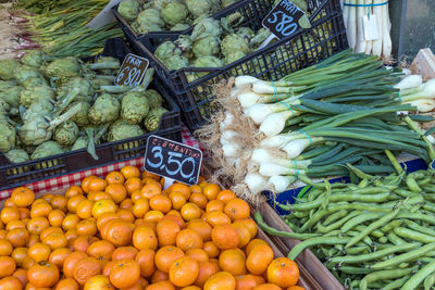 Tangerines, leek and artichokes for sale at a market