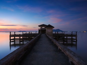 Pier over sea against sky during sunset