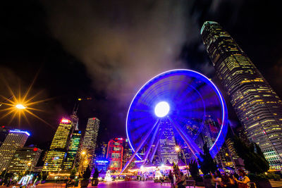 Illuminated ferris wheel in city at night