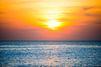 Scenic view of sea against dramatic sky during sunset