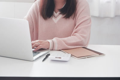 Midsection of woman using mobile phone