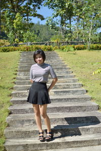 Portrait of young woman standing on staircase