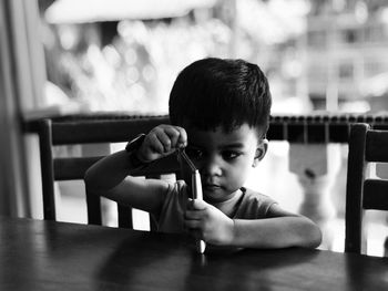 Cute boy playing toy on table at home