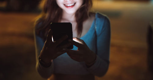 Midsection of woman using mobile phone