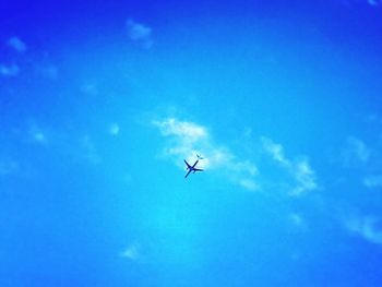 Low angle view of helicopter in blue sky