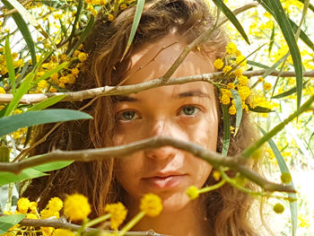 Close-up portrait of woman amidst yellow flowers