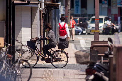 People riding bicycle on street in city