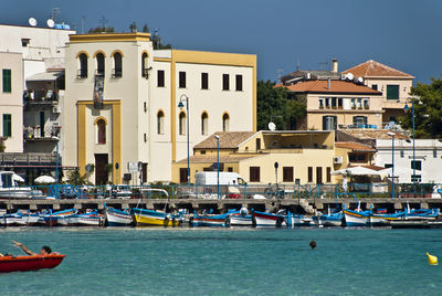 Boats moored in canal by buildings in town