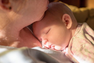 Close-up of woman with sleeping toddler at home