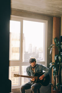 Man playing guitar in window