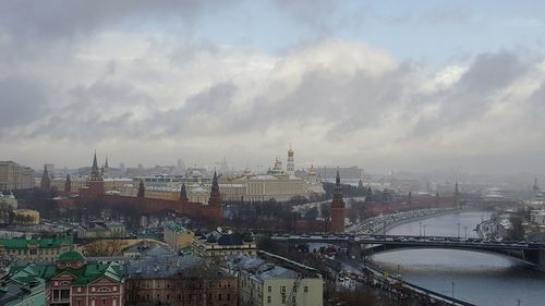 View of cityscape against cloudy sky