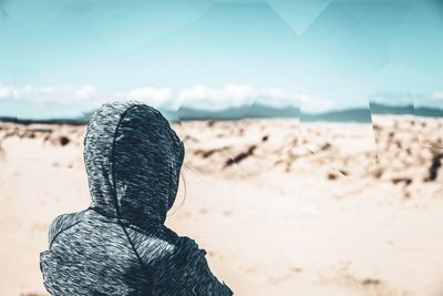 Rear view of man on beach against sky