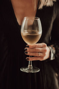 Midsection of man holding glass of wine