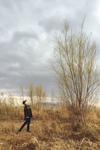 Man with umbrella against sky during sunset