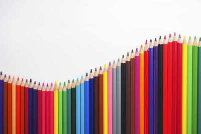 Close-up of multi colored pencils against white background