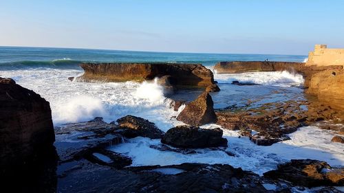 Rocks in sea against sky