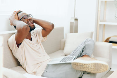 Young woman using laptop on bed at home