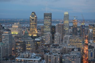 Aerial view of buildings in city against cloudy sky