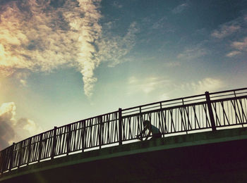 Low angle view of bridge against cloudy sky