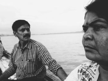 People in boat on lake against sky