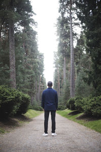 Rear view of man standing on footpath against sky