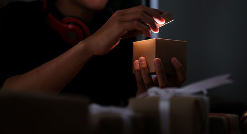 Midsection of woman holding illuminated paper