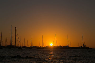 Silhouette of sailboat sailing on sea during sunset