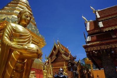 Low angle view of statue amidst buildings against sky