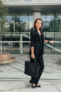 Portrait of young woman standing in city