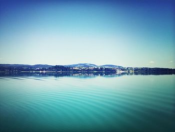 Calm sea against clear blue sky