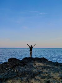 Man standing on beach by sea against sky