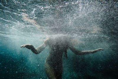 Midsection of woman swimming in sea