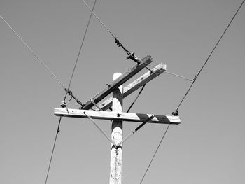 Low angle view of telephone pole against clear sky