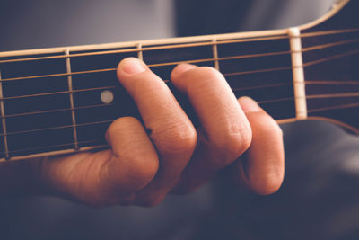 Close-up of hands playing guitar