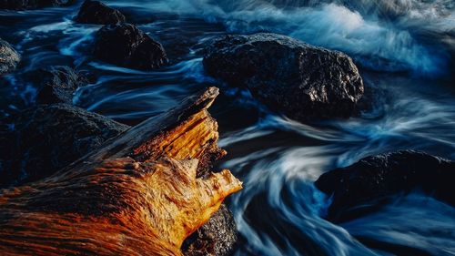 High angle view of waves splashing rocks in sea