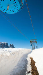 Low angle view of snowcapped mountain against clear blue sky