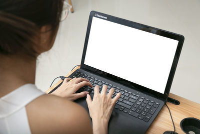 Midsection of woman using laptop on desk