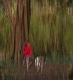 Blurred motion of woman running on field