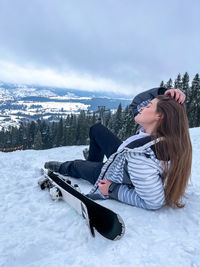 Shot of a skier woman sitting on the ski slope resting relaxing extreme recreation active lifestyle