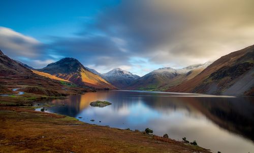 Scenic view of lake by mountains against sky