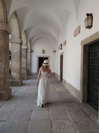 Rear view of woman standing against building