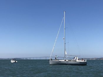 Sailboat sailing on sea against clear sky