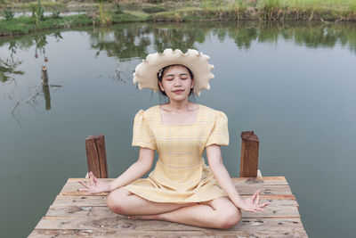 Beautiful young woman doing yoga in nature. girl sitting on a wooden bridge.