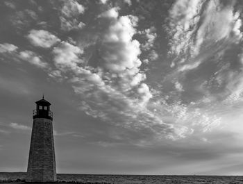 Lighthouse by sea against sky