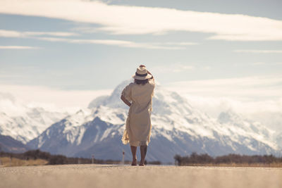 Woman standing against snowcapped mountains