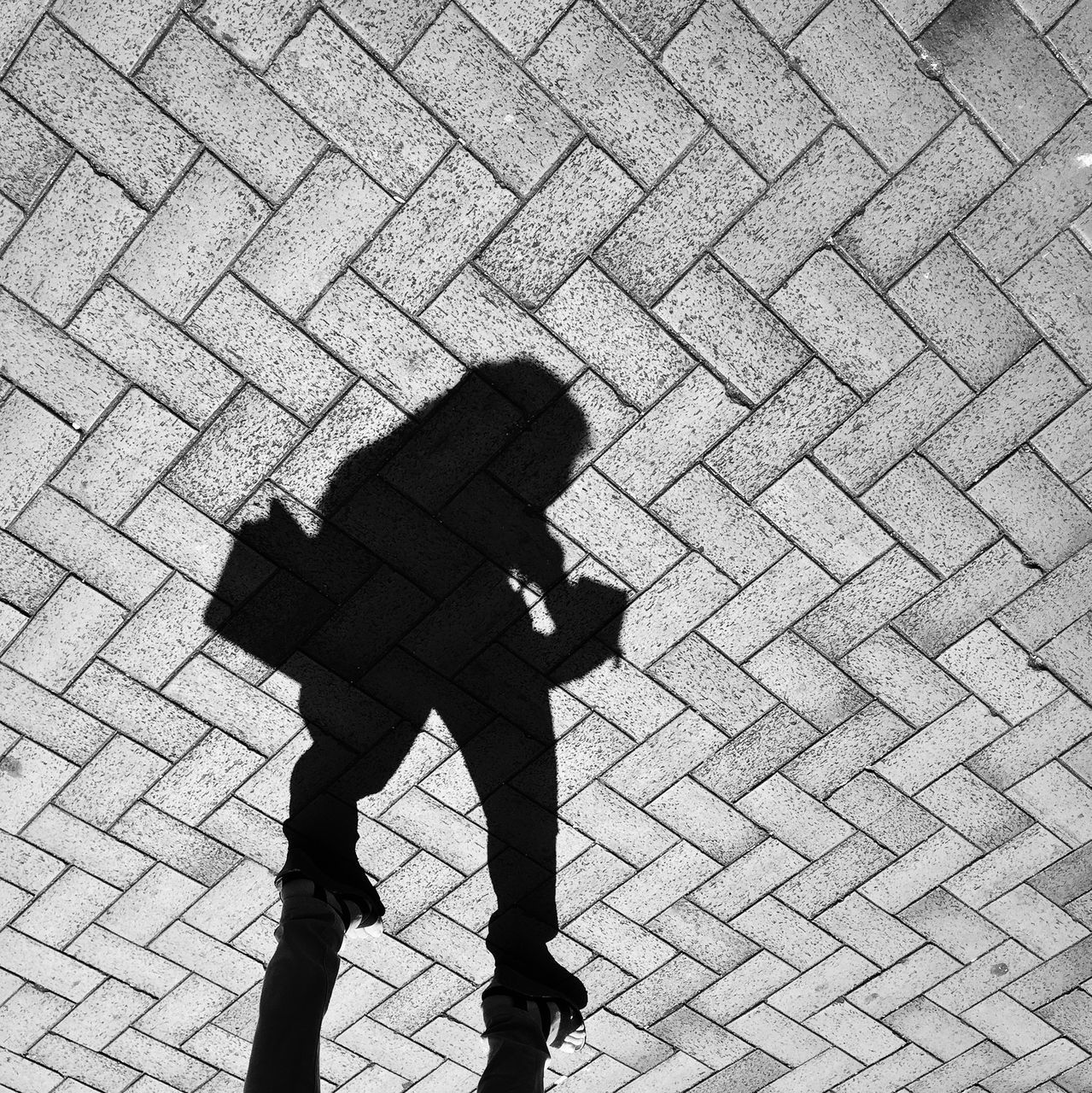 shadow, focus on shadow, high angle view, street, sunlight, silhouette, cobblestone, standing, men, lifestyles, paving stone, sidewalk, human representation, outdoors, unrecognizable person, day, footpath, leisure activity