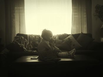 Boy sitting on sofa at home