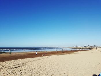 Scenic view of beach against clear blue sky